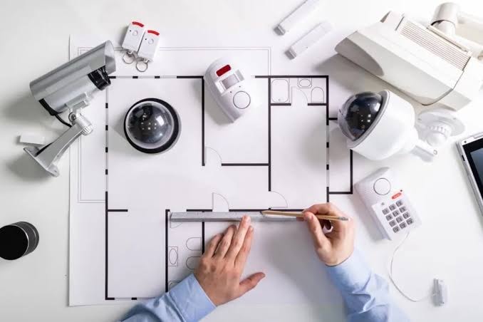 Security system designer planning camera and sensor placement on a building floor plan